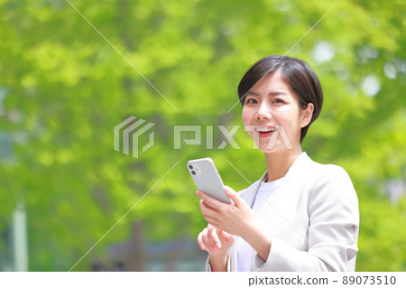 Business woman who raised her face from her smartphone 1 89073510