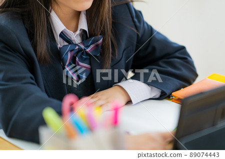 High school girl studying at home on a tablet High school girl studying at home on a tablet 89074443