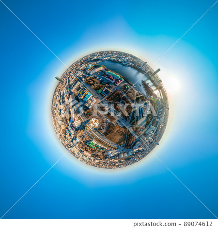 Aerial early spring or autumn city view with crossroads and roads, houses, buildings, parks and bridges. Copter shot. Little planet sphere mode. 89074612