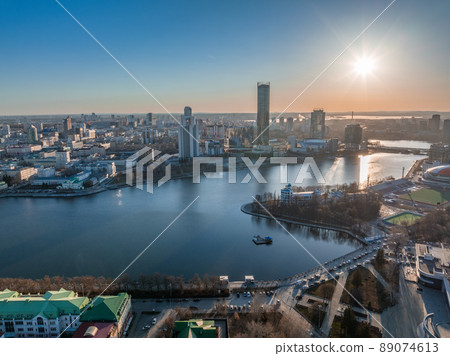 Yekaterinburg city and pond aerial panoramic view at early spring or autumn in clear sunset. Yekaterinburg city and pond aerial panoramic view at early spring or autumn in clear sunset. 89074613