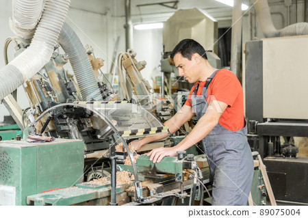 Master operating wood turning machine in workshop 89075004