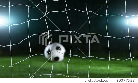 Soccer ball in front of goal on black background Soccer ball in front of goal on black background 89077538