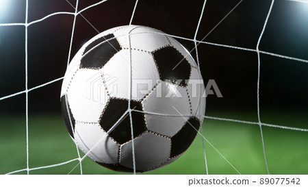 Soccer ball in goal, isolated on black background 89077542