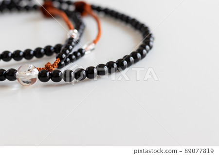 Black beads on a white desk Black beads on a white desk 89077819
