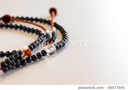 Black beads on a white table Black beads on a white table 89077845
