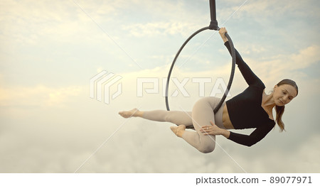Woman in sportswear doing sky yoga on the rooftop in the evening when the sun set. Self care and health concepts. Woman in sportswear doing sky yoga on the rooftop in the evening when the sun set. Self care and health concepts. 89077971