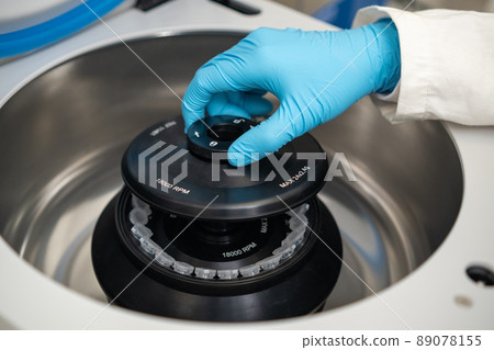 Female lab technician in rubber gloves refills a centrifuge and close the cap. DNA test or onglogy marker tests concept. Female lab technician in rubber gloves refills a centrifuge and close the cap. DNA test or onglogy marker tests concept. 89078155