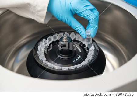 Scientist puts microcentrifuge tubes into centrifuge for phase separation. DNA and cell analysis at microbiology laboratory. Scientist puts microcentrifuge tubes into centrifuge for phase separation. DNA and cell analysis at microbiology laboratory. 89078156