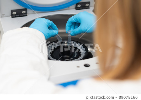 Laboratory worker puts chemical tubes into the centrifuge. Biochemistry and research laboratory concept. DNA and pharmaceutical analysis.  89078166