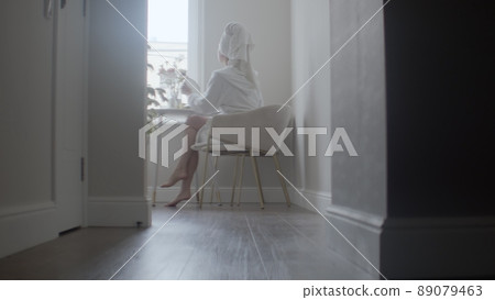 A young girl takes care of her face, washing with cream and balm after a shower. Skin care 89079463