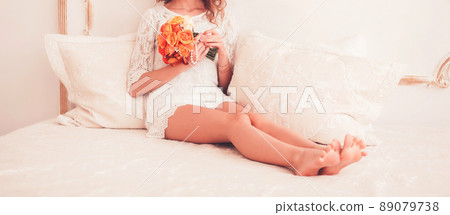 young woman sitting with a bouquet 89079738
