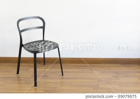 Modern black steel chair on wood floor in empty room. Modern black steel chair on wood floor in empty room. 89079875