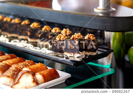 Chocolate cake with walnuts without baking. Dessert table in a Turkish hotel. Various cakes and sweets on buffet. Chocolate cake with walnuts without baking. Dessert table in a Turkish hotel. Various cakes and sweets on buffet. 89082267