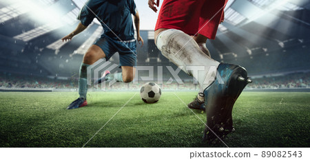 Cropped image of two soccer, football players in motion, action at stadium during football match. Concept of sport, competition, goals 89082543