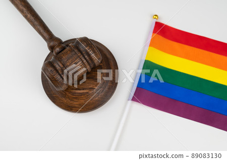 Judge gavel and hand lgbt flag on white background. 89083130