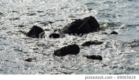 Rock at sea with surf background Rock at sea with surf background 89083628