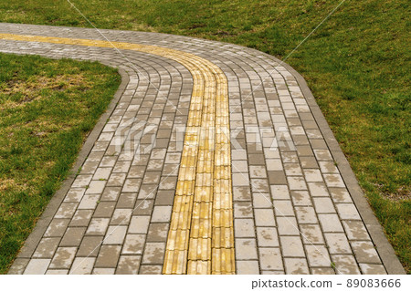 Path curving through lawn in park 89083666