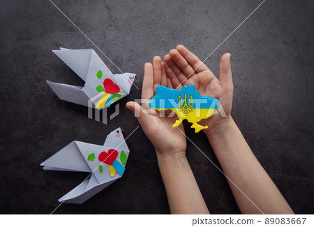 Hands holding the shape of Ukraine border with color flag Hands holding the shape of Ukraine border with color flag 89083667