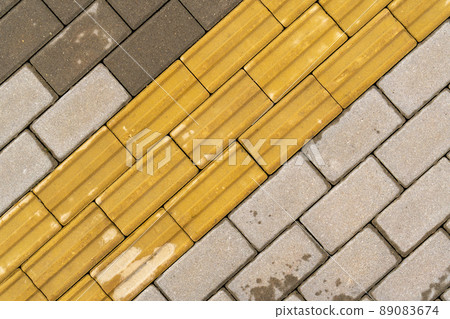Sidewalk with yellow tactile paving 89083674