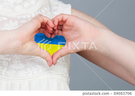 Love Ukraine concept. Woman with Ukrainian flag in heart Love Ukraine concept. Woman with Ukrainian flag in heart 89083706