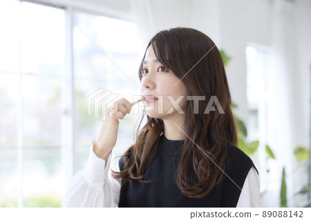 A woman brushing her teeth with a bamboo toothbrush 89088142