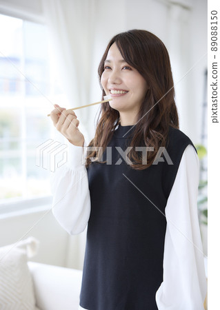 A woman brushing her teeth with a bamboo toothbrush 89088150