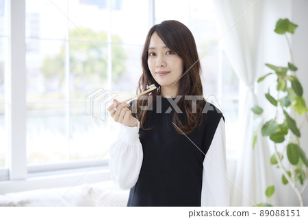 A woman brushing her teeth with a bamboo toothbrush 89088151