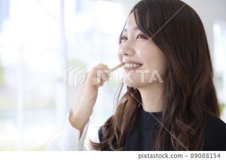 A woman brushing her teeth with a bamboo toothbrush 89088154