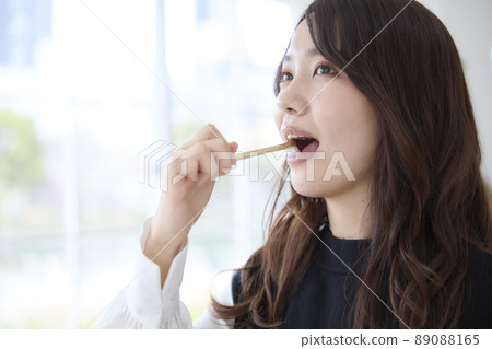 一個女人用竹牙刷刷牙 89088165