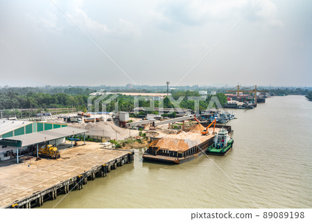 Aerial time lapse view of an excavator working on a carrier boat at Tapi river in Surat Thani, Thailand 89089198