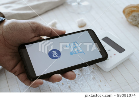 man pays the bill with his smartphone 89091074