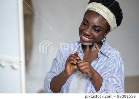 Contented african woman holding mascara in hands Contented african woman holding mascara in hands 89091559