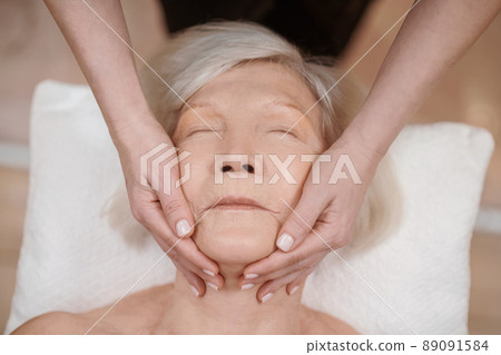 A senior woman having an anti-age massage in a beauty salon 89091584