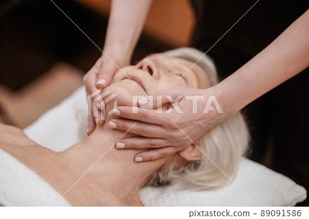A senior woman having an anti-age massage in a beauty salon A senior woman having an anti-age massage in a beauty salon 89091586