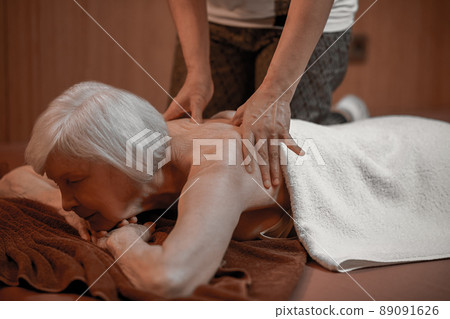 A senior woman having back massage in a beauty salon 89091626