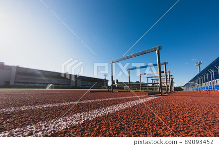Hurdle race barrier on stadium track at sunny day. Blue sky 89093452