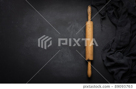 Old wooden rolling pin for rolling dough on a black background, top view Old wooden rolling pin for rolling dough on a black background, top view 89093763