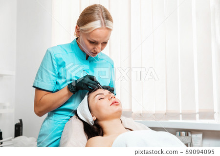 Professional cosmetology in salon. Doctor doing acne treatment using mechanical steel instrument. Concept of cleansing blackhead procedure Professional cosmetology in salon. Doctor doing acne treatment using mechanical steel instrument. Concept of cleansing blackhead procedure 89094095