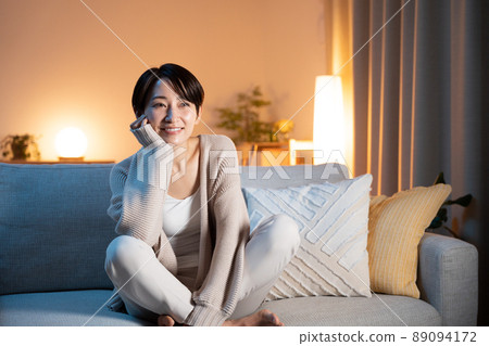 Woman relaxing at home at night Woman relaxing at home at night 89094172
