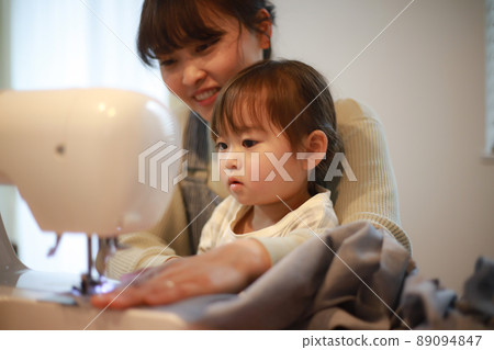 Parents and children using a sewing machine Parents and children using a sewing machine 89094847