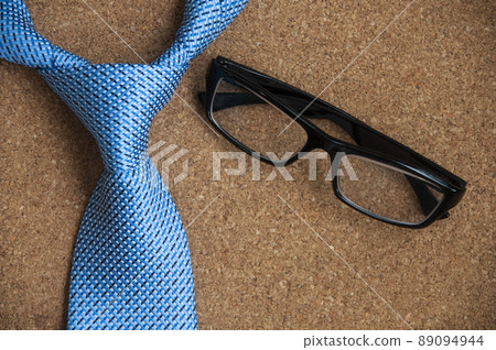 Top view of blue necktie and glasses on wooden background. Copy space and Idea concept. 89094944