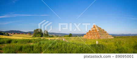 stack of straw bales on field of grass, landscape with meadow, forest and hills stack of straw bales on field of grass, landscape with meadow, forest and hills 89095001
