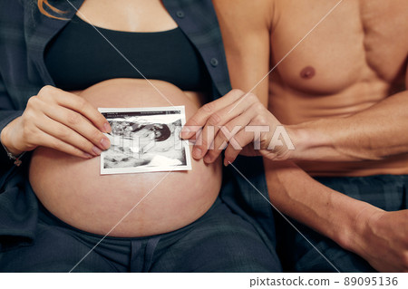 Pregnant couple holding ultrasound scan. Concept of Pregnancy health care. Pregnant couple holding ultrasound scan. Concept of Pregnancy health care. 89095136