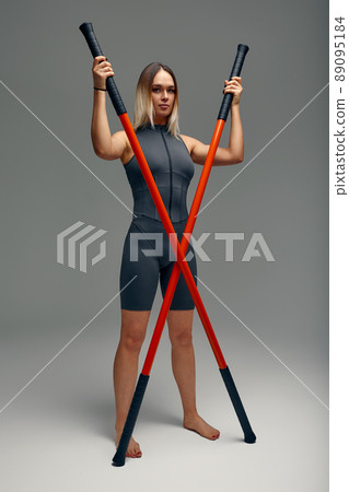 beautiful girl in sports uniform is training kung fu in the studio, fighter athlete, practicing martial arts with a stick beautiful girl in sports uniform is training kung fu in the studio, fighter athlete, practicing martial arts with a stick 89095184