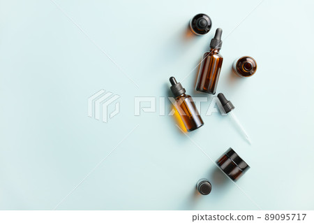 Amber glass cosmetic bottles mockups on blue background. Natural organic beauty product packaging design. Amber glass cosmetic bottles mockups on blue background. Natural organic beauty product packaging design. 89095717