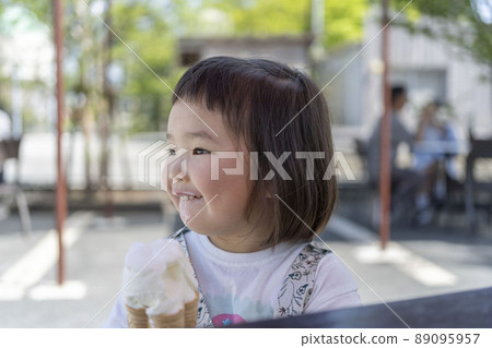 Cute toddler eating ice cream on a hot day Cute toddler eating ice cream on a hot day 89095957