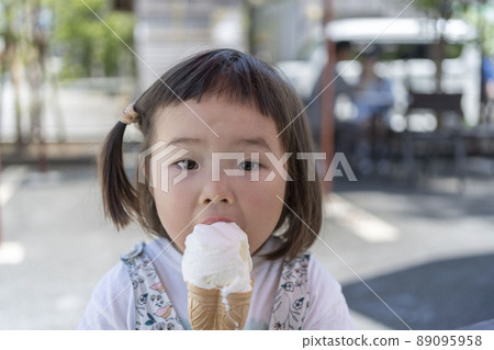 Cute toddler eating ice cream on a hot day Cute toddler eating ice cream on a hot day 89095958