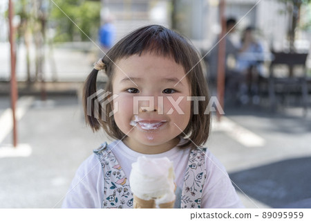 可愛的蹣跚學步的孩子在炎熱的一天吃冰淇淋 可愛的蹣跚學步的孩子在炎熱的一天吃冰淇淋 89095959