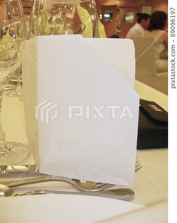 Wedding card surrounded by glasses, couple writing 89096197