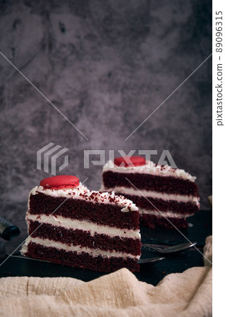 two pieces of red velvet cake with cookies on top 89096315